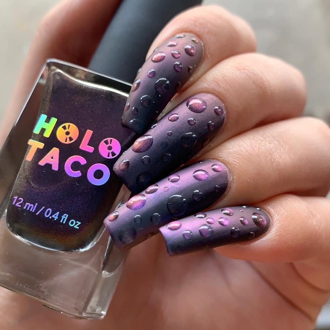 Raindrop nail art on a blue-grey background