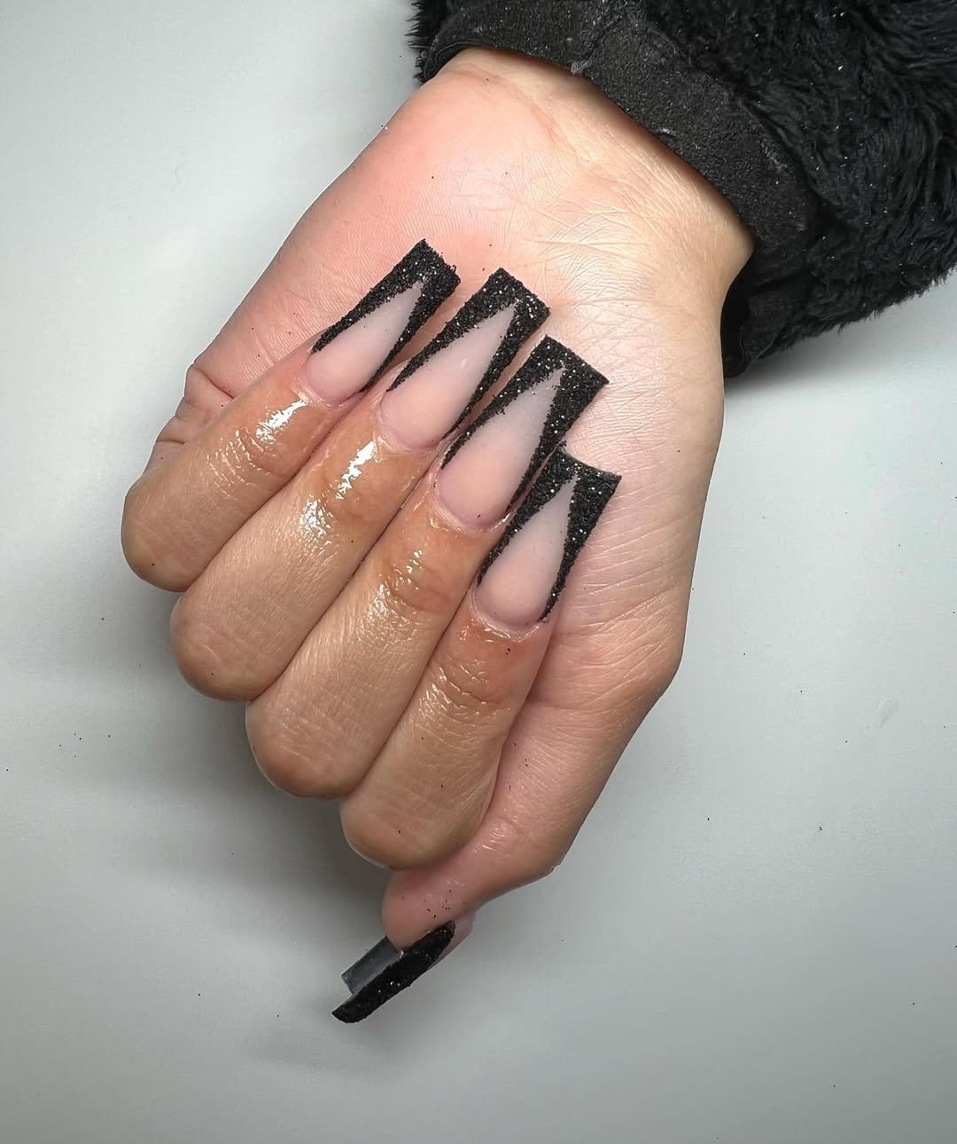 Glitter V-cut French tip nails in shimmering design
