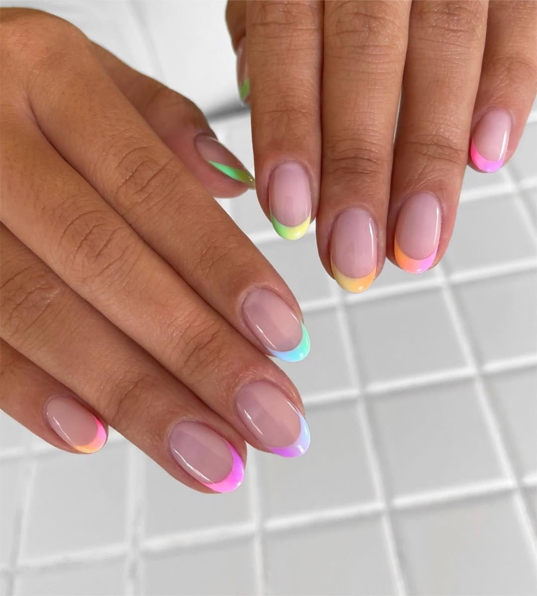 Pastel rainbow French tip nails in soft hues