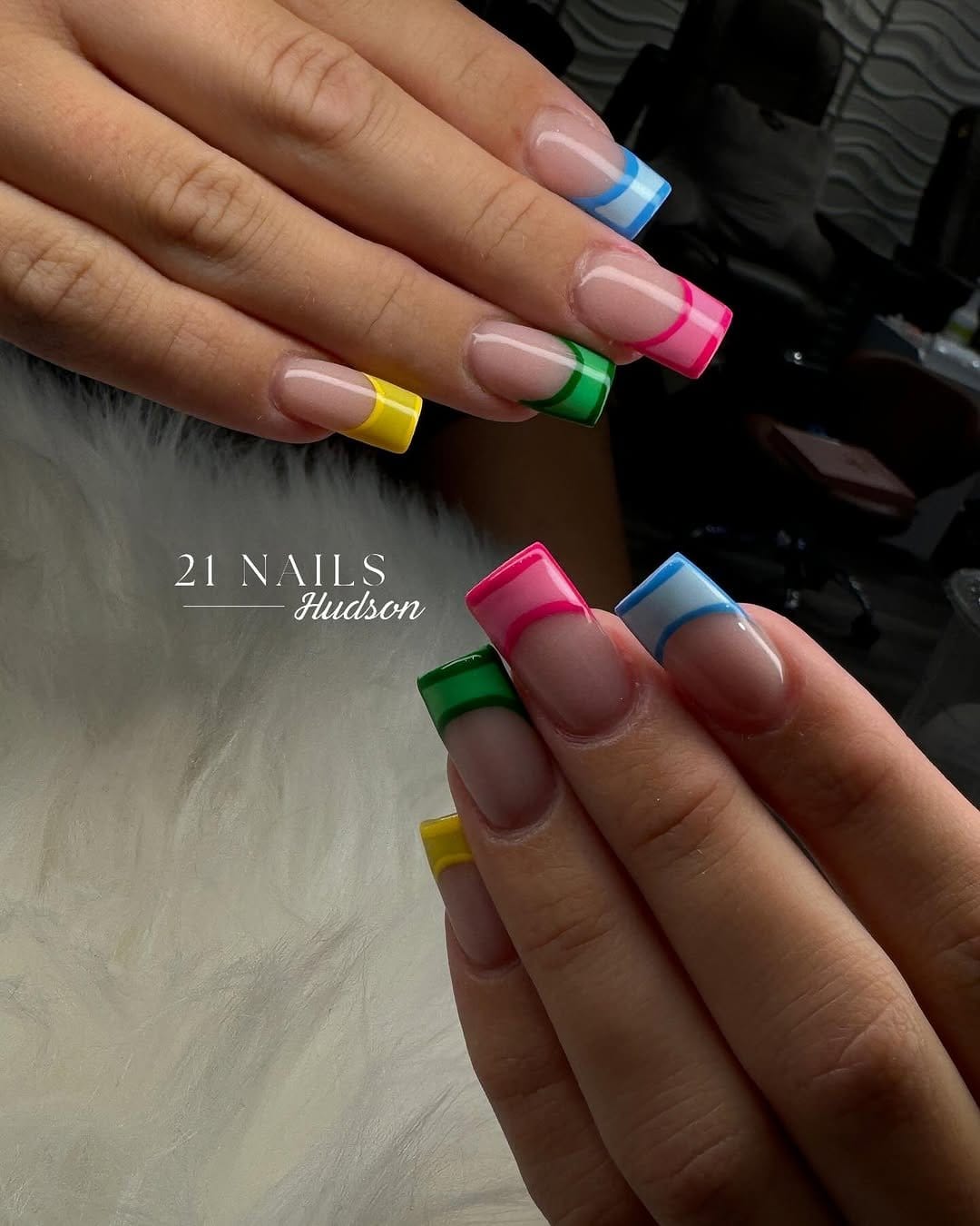 Colorful striped French tip nails in vibrant hues