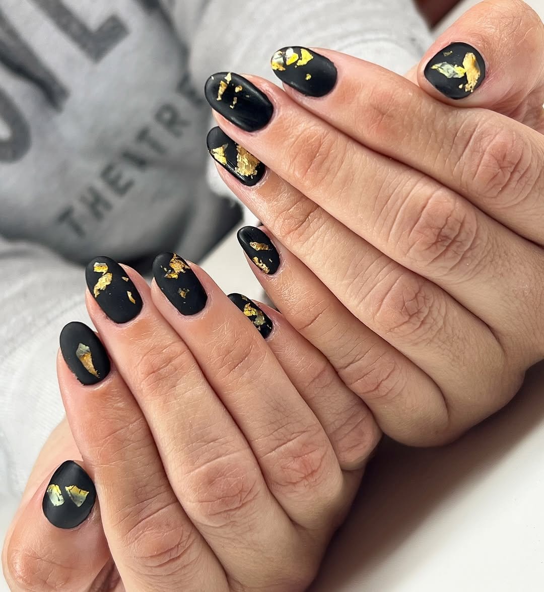 Matte black nails with gold accents