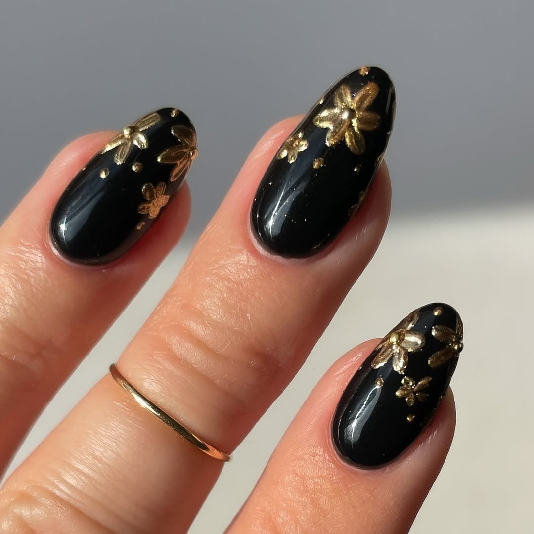 Metallic floral nail art on a dark base