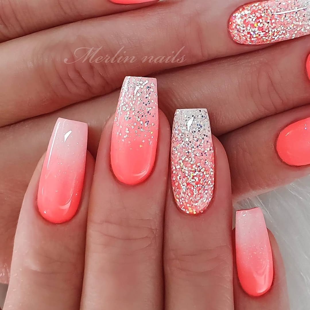 Glittery red ombre nails sparkling in sunlight