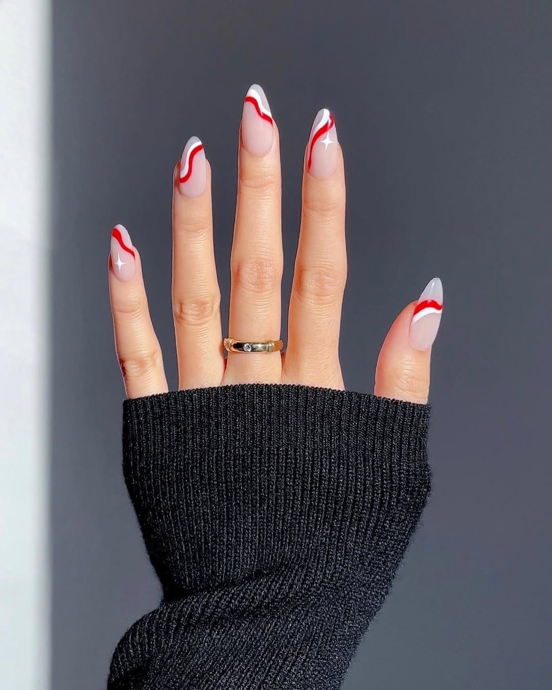 Red nails with white swirl patterns