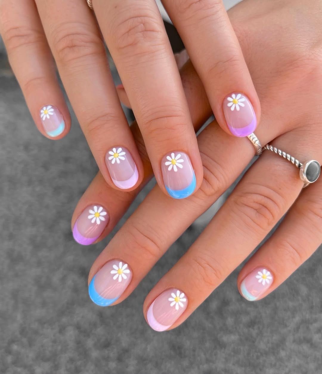 White daisy nail art on pastel background