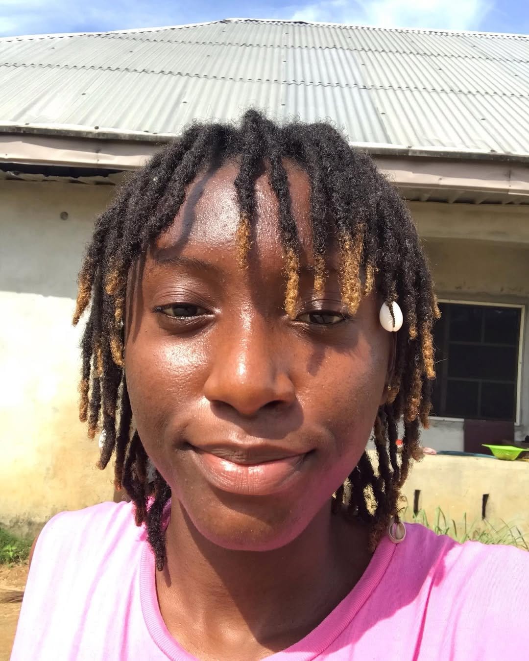 Short dreadlocks adorned with seashells