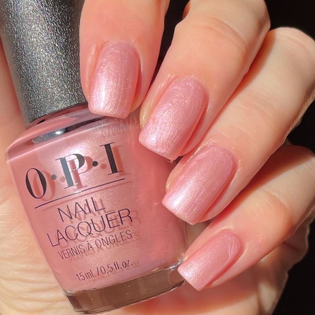 Glossy pastel pink nails with pearl accents