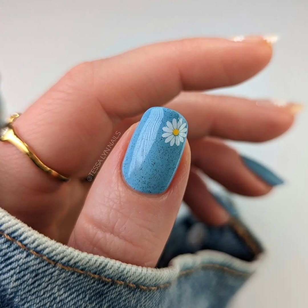 Simple daisy nail art on blue background