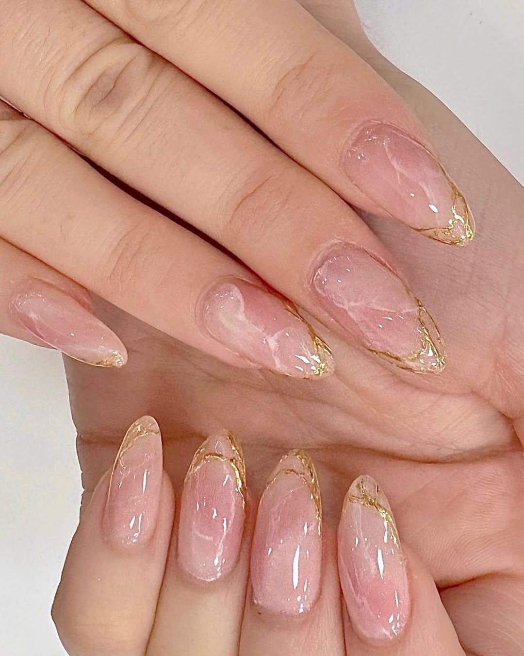 Elegant marbled nail art in soft pink and gold
