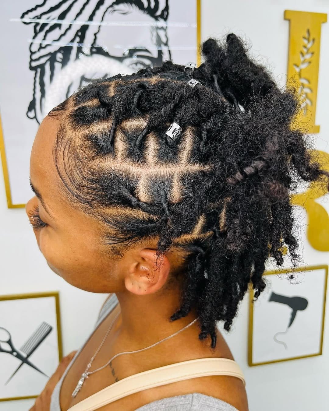 Short dreads styled in a half-up bun