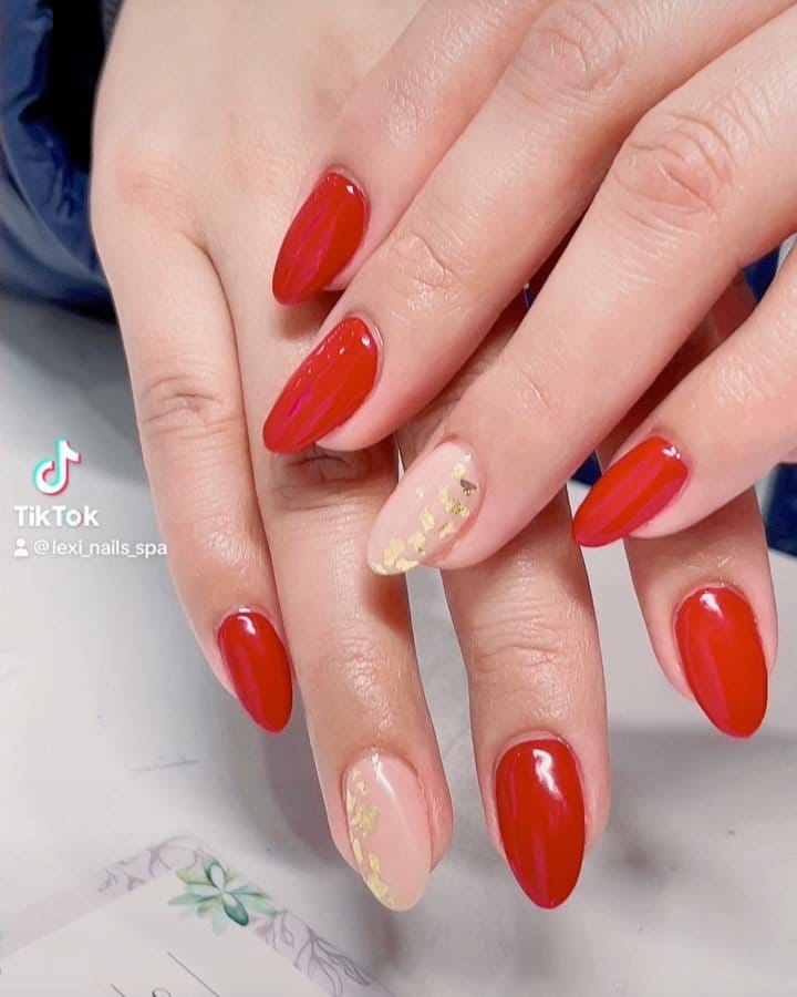 Red nails with gold leaf embellishments