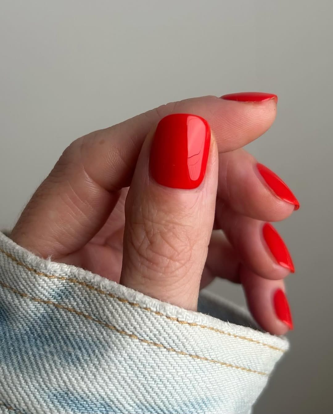 Bright coral nail polish bottle