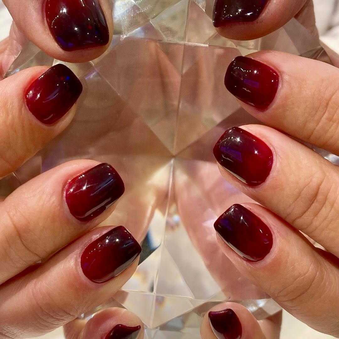 Red ombre nails with silver stripe accents