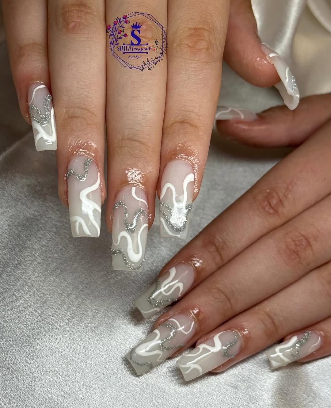 White nails with glitter swirl patterns