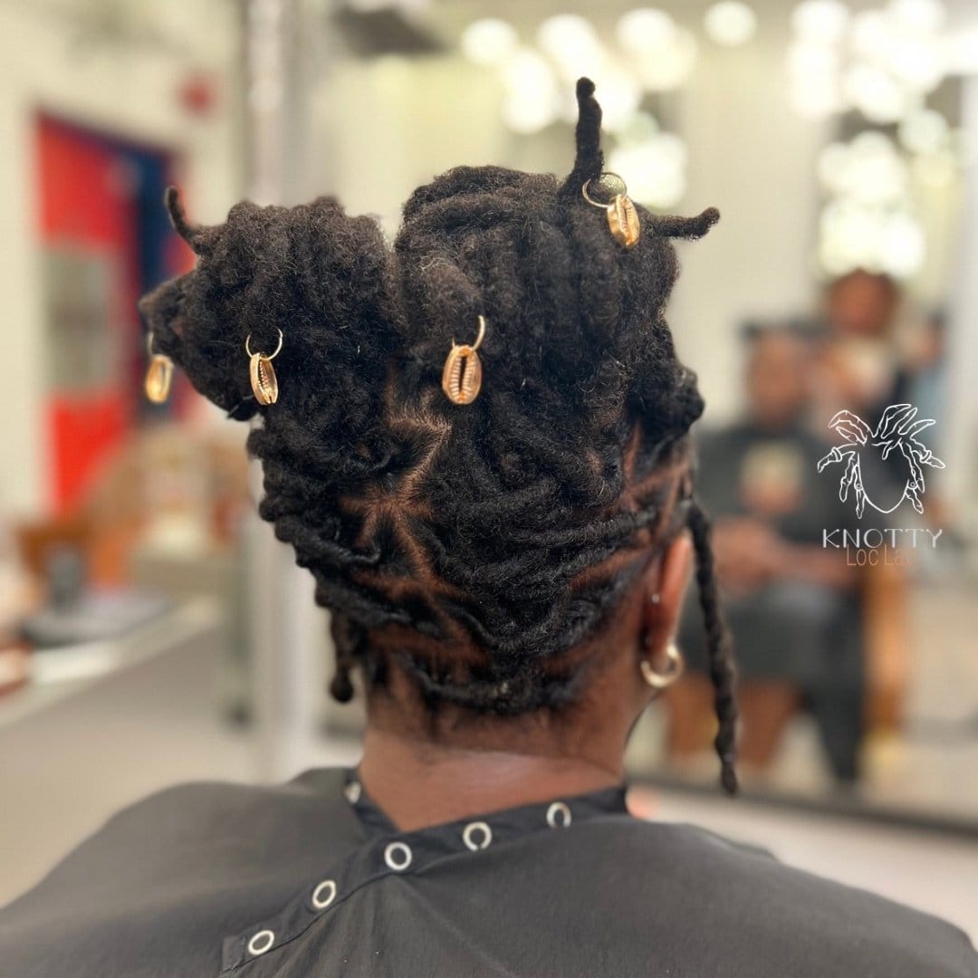 Short locs styled in space buns