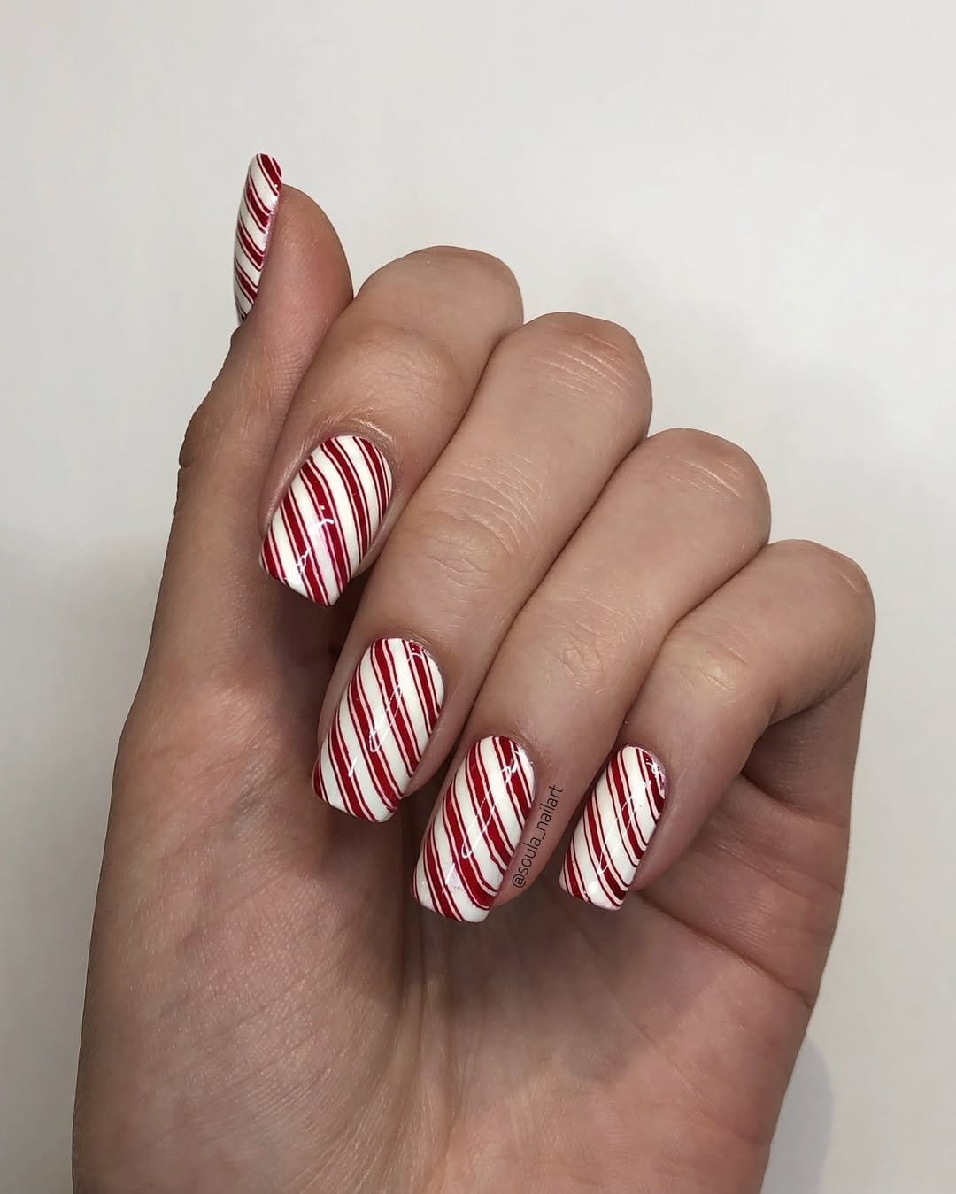 Red nails with candy cane stripe pattern