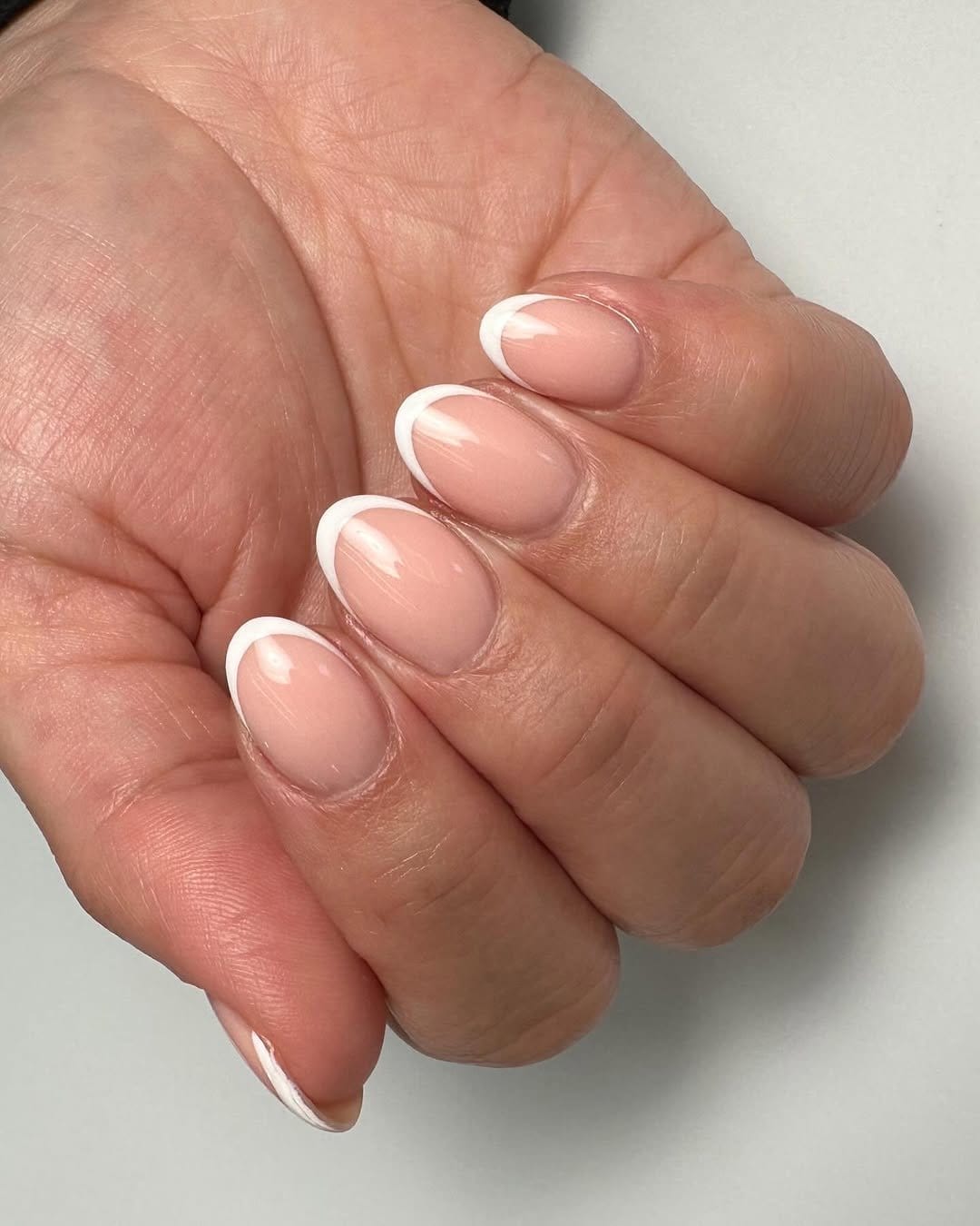 Shiny classic white nails with a spring backdrop
