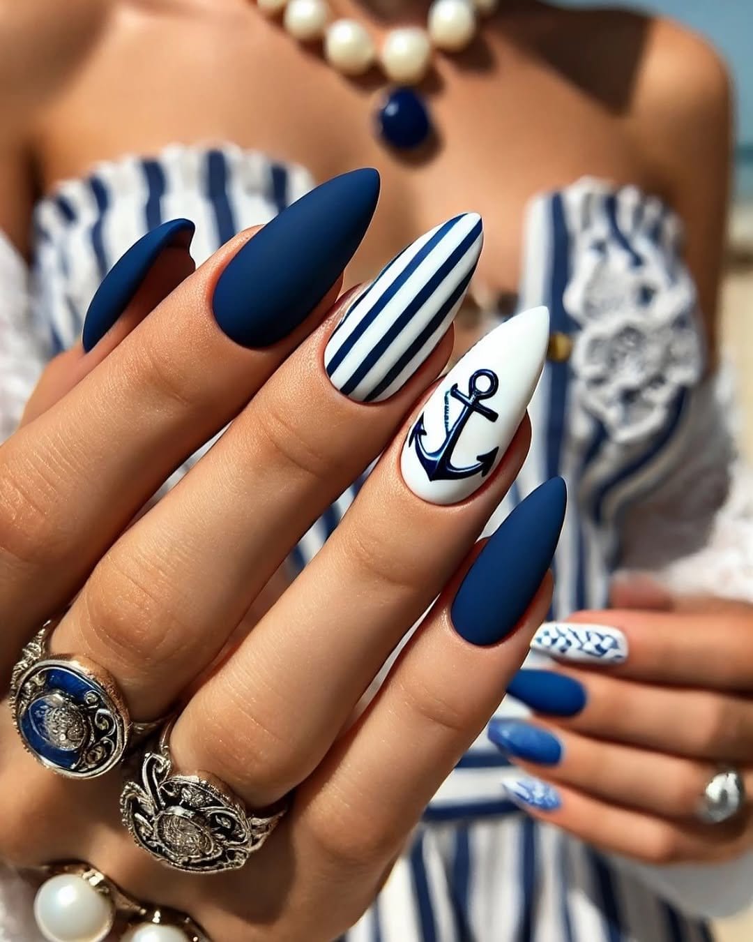 Navy and white striped nail design with anchor accent