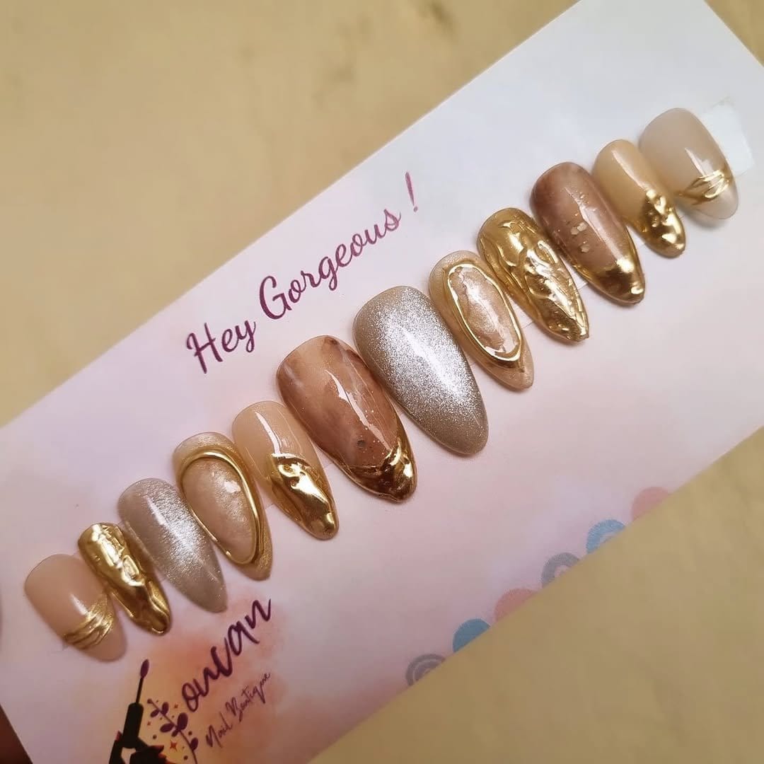 Shimmery metallic nail art with gold accents