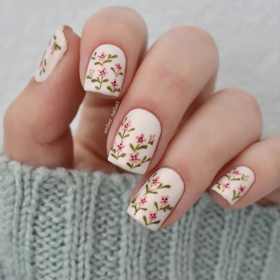 Pastel pink nails with delicate floral designs