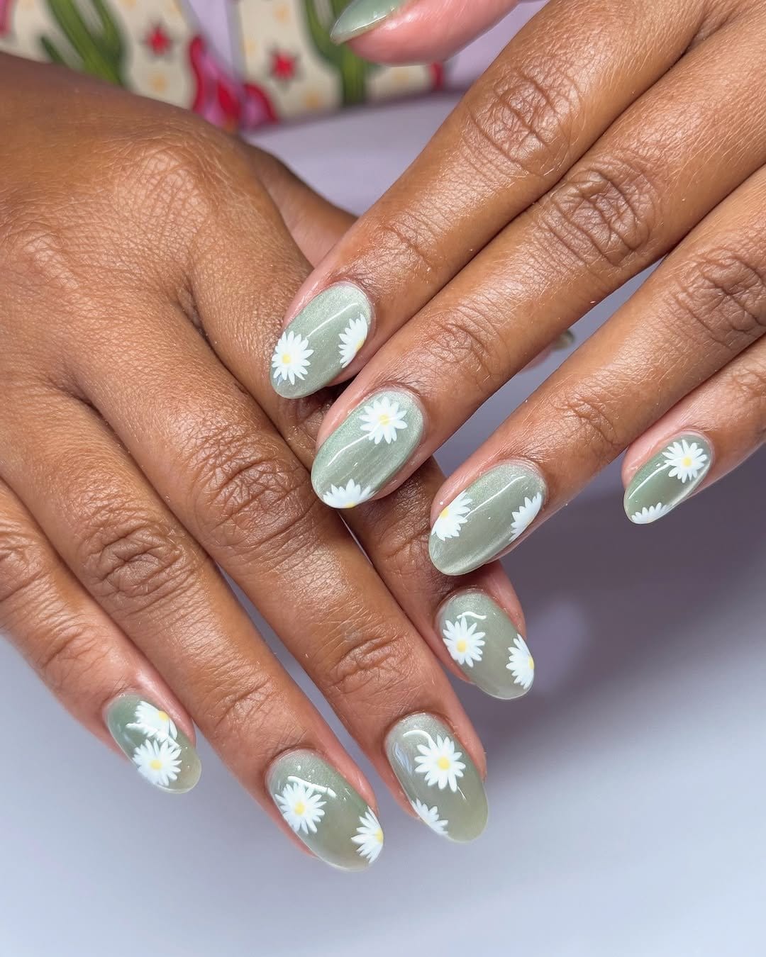 White daisy nail art on a green background