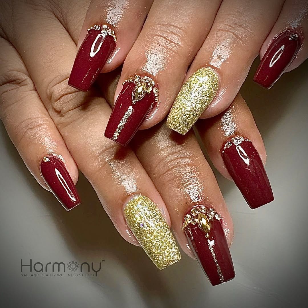 Red ombre nails adorned with jewels
