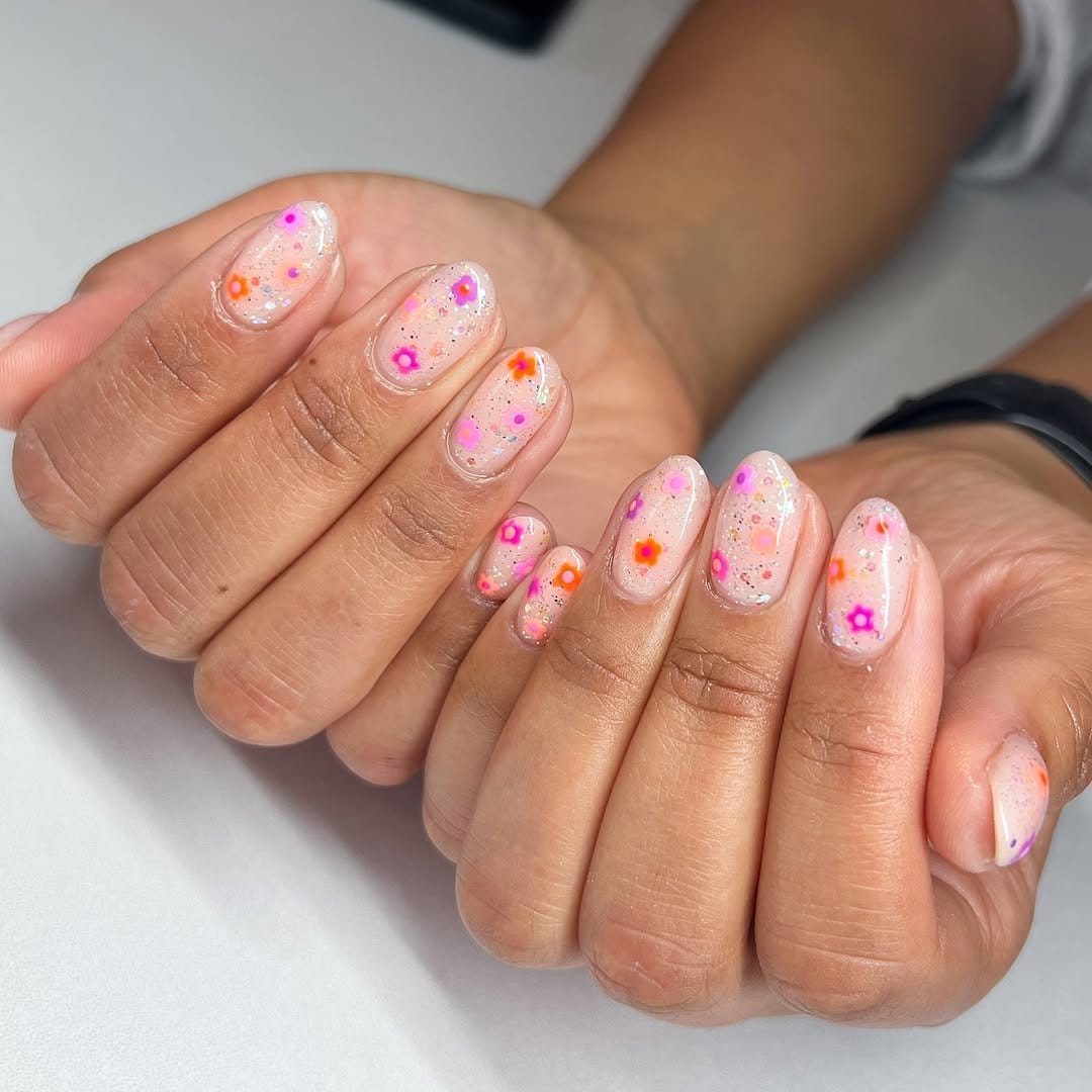 Glittery floral nail design with a clear base