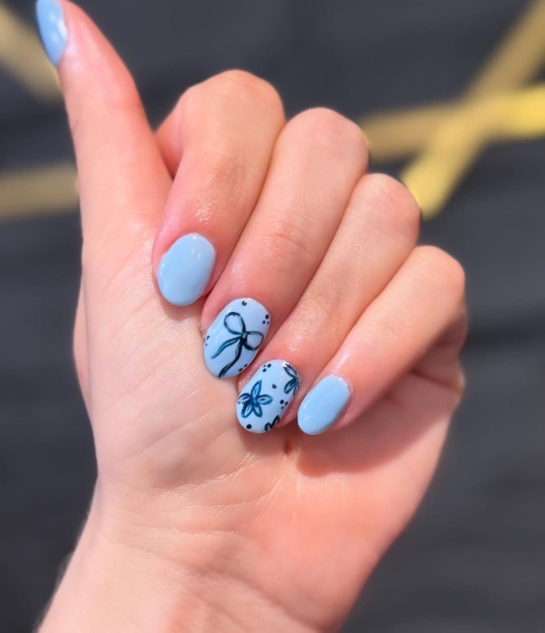 Simple dandelion nail art on a sky-blue background