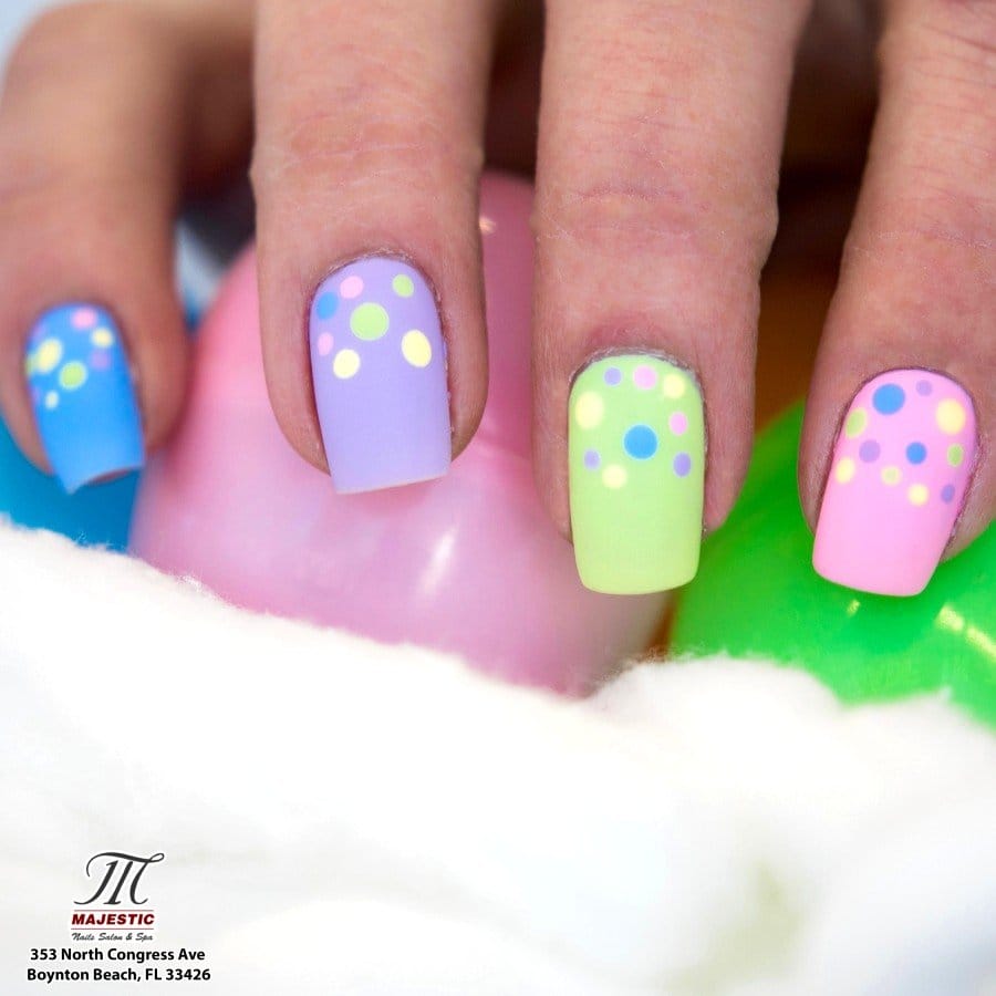 Colorful polka dot nail art on pastel base