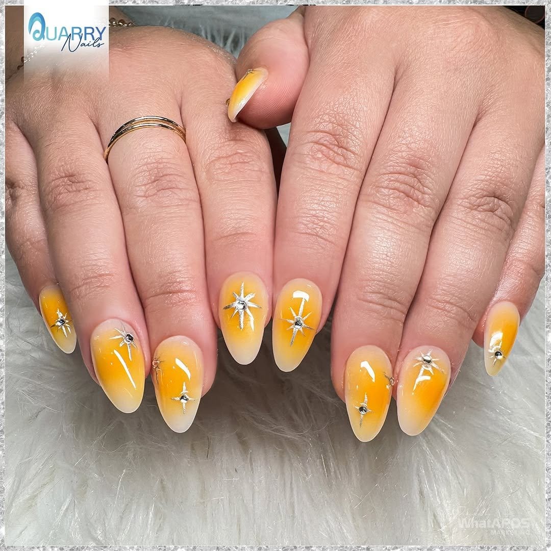 Bright yellow nails with sun motifs
