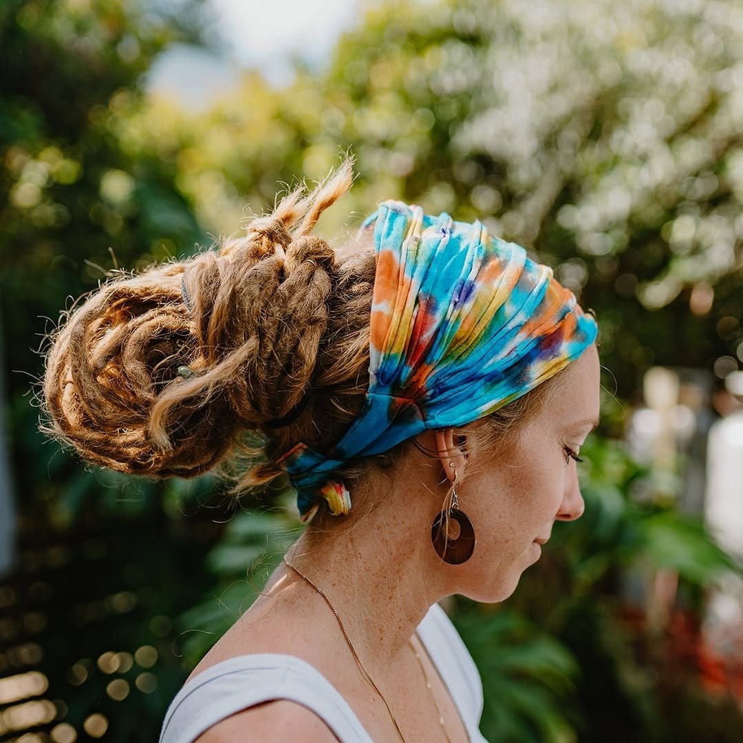Short dreadlocks wrapped with a colorful bandana