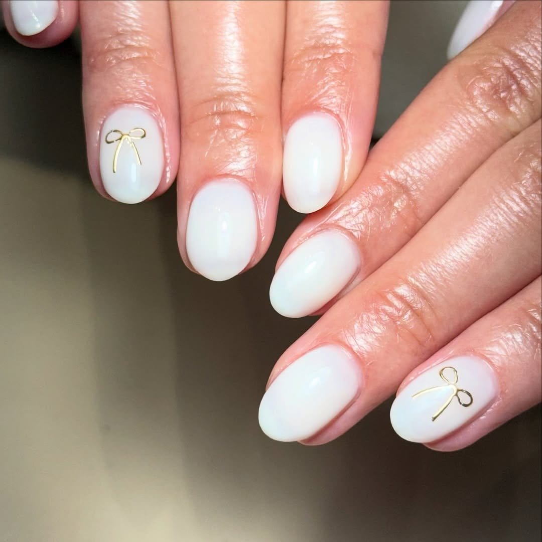 White nails with gold accent stripes