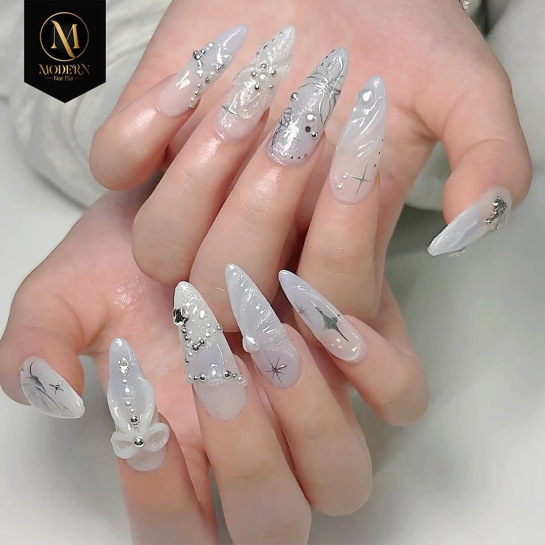 Red nails adorned with small pearl accents