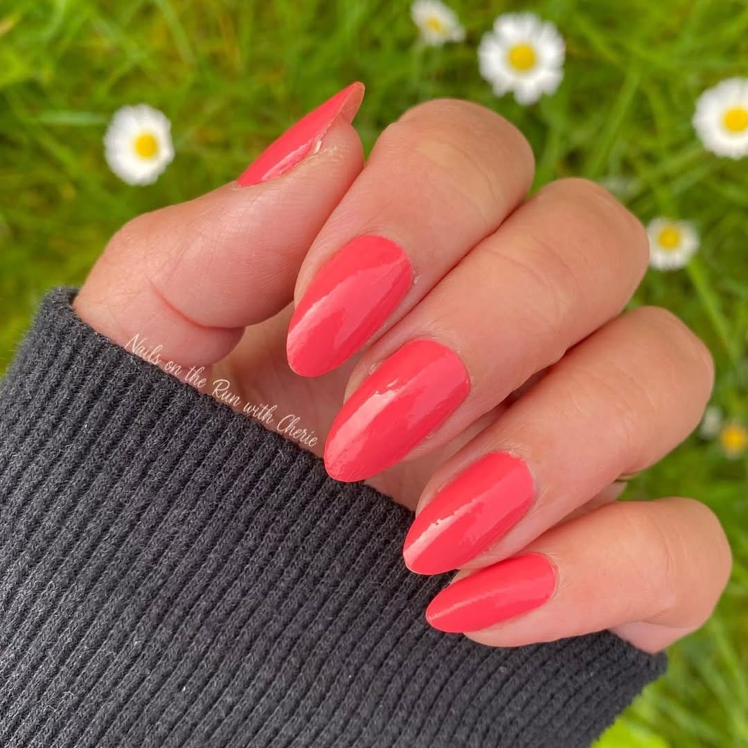 Bright coral nails with glossy sheen